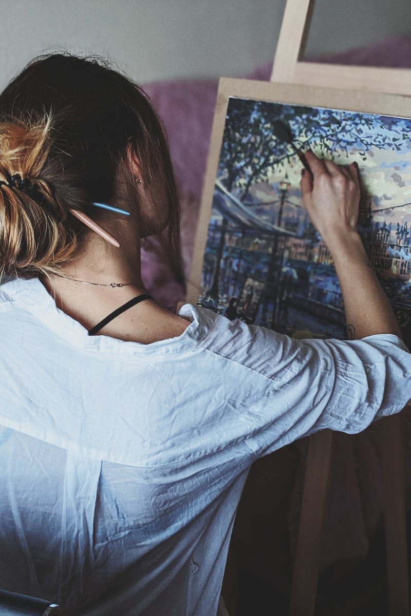 An artist captures a London cityscape on canvas at an indoor studio.